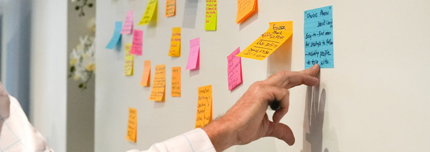 Generate ideas with post it notes on a large whiteboard